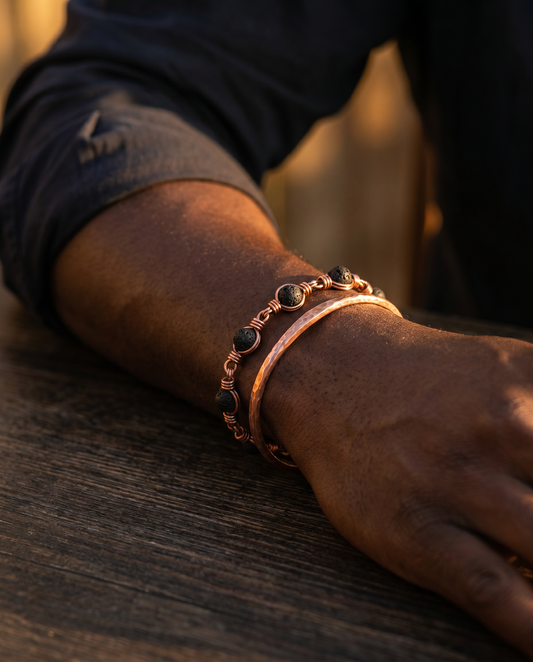 Copper bangle and lava stone bracelet worn stacked on the wrist