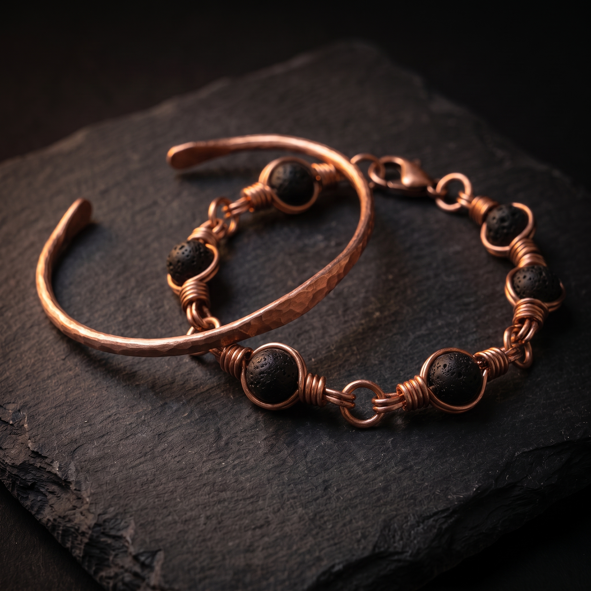 Copper bangle and lava stone bracelet bundle on dark slate